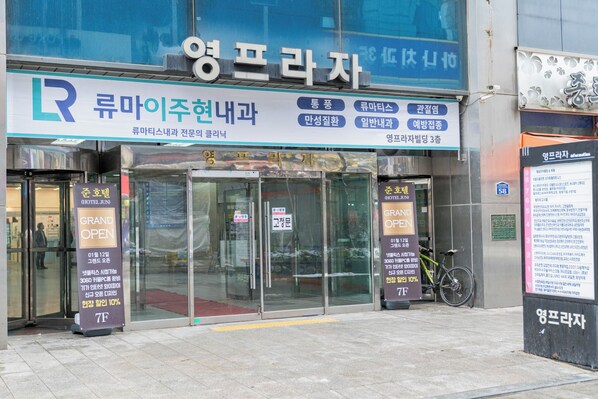 A hotel entrance with glass doors, a sign indicating 'Grand Open' and '7F'. - Hwajeong Hotel jun (Goyang)
