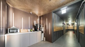 Une cuisine moderne équipée d’un four à micro-ondes, d’une machine à café et d’un petit réfrigérateur.
