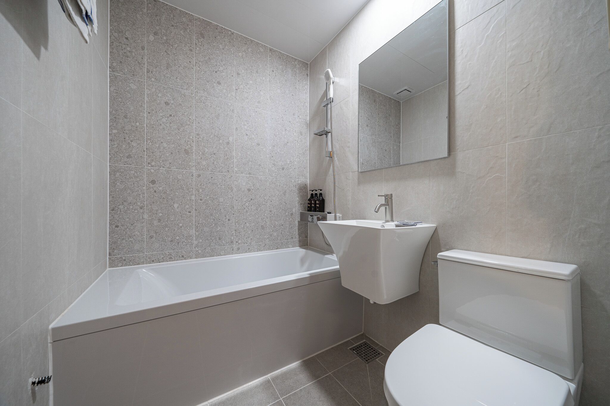 Un baño moderno con bañera, lavamanos e inodoro.
