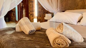 A room with a bed, white pillows, and rolled towels. - Casa da Namaacha

 (Naamacha)