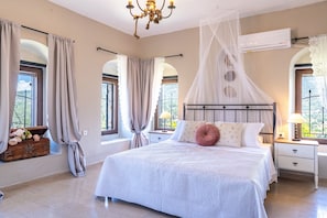 Una camera da letto con un letto grande, un comodino, un settimino in legno e una finestra con tende.