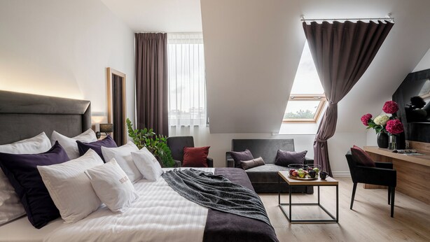 Ein modernes Hotelzimmer mit einem großen Bett, einem Schreibtisch und einer Sitzecke.
