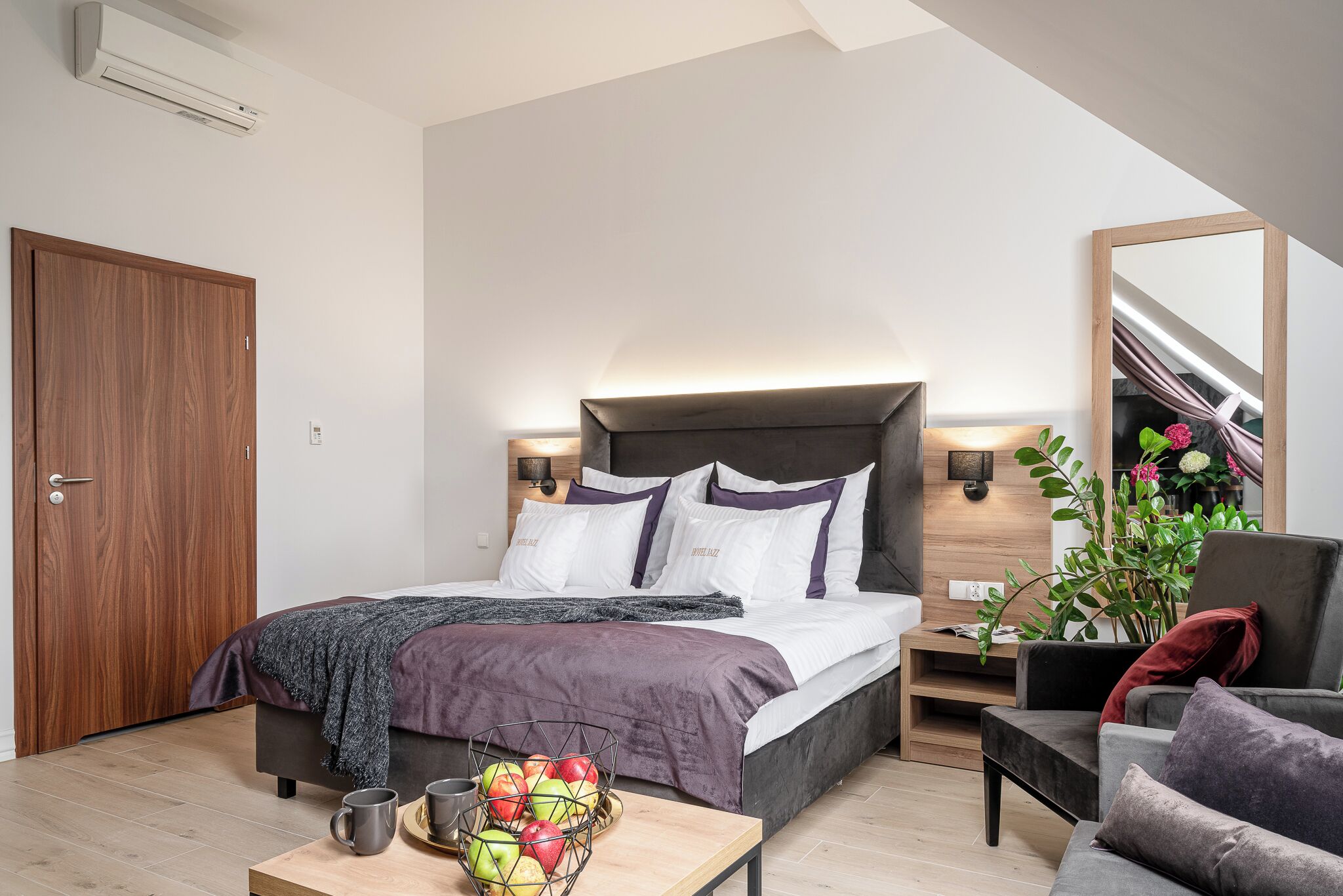 Un dormitorio moderno con cama, mesita de noche y una silla.