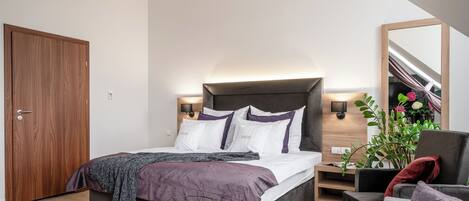 Un dormitorio moderno con cama, mesita de noche y una silla.
