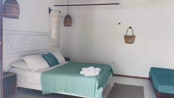 Une chambre à coucher comprenant un lit, une table de chevet, une lampe suspendue, un panier fixé au mur et une fenêtre avec des rideaux.