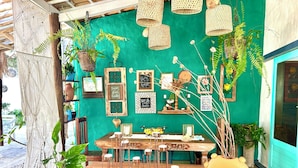 A cozy outdoor seating area with a wooden table, chairs, and a variety of potted plants. - Pousada La Vida Boutique (Amontada)