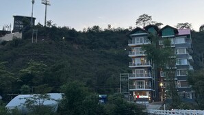 A multi-story hotel with balconies and a sign that reads "HOTEL LITVOS". - SOLITUDE (Dharamshala)
