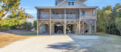 A two-story house with a balcony, a covered porch, and a staircase leading to the upper level.