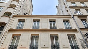A multi-story building with a classical architectural style, featuring symmetrical windows and ornate balconies. - Terrace Apartment Trocadero Eiffel Tower (Paris)