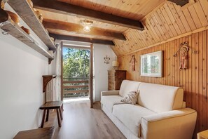 A wooden interior with a sofa, a table, and a bench.