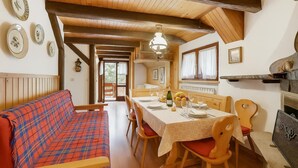 A cozy dining area with a wooden table set for four, surrounded by wooden chairs. - Appartamento Beau Soleil ski in ski out (Sauze d'Oulx)
