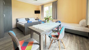 A hotel room with a bed, a desk, a chair, and a TV. - Pensjonat Błękitna Przystań (Puck)