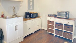 A compact kitchen with a sink, coffee maker, microwave, toaster, and storage cabinets. - Cozy SAFE 1 BR Private apartment Traveling Professionals near skiing Hospitals (Exeter)