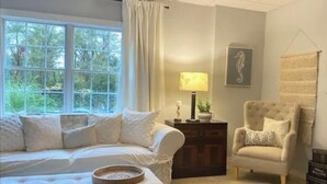 A bedroom with a large window, a bed, a chair, a nightstand, and a lamp. - Cozy SAFE 1 BR Private apartment Traveling Professionals near skiing Hospitals (Exeter)