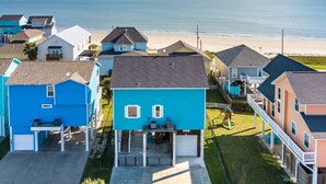 A coastal residential area with houses, a beach, and a clear sky. - Crystal Breeze - beautiful 3 bdrm, with gulf view - just steps to the beach! (Crystal Beach)