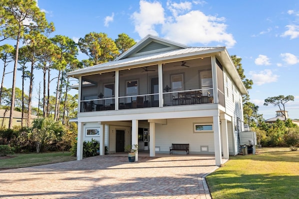 Enjoy a meal on the two-story house's spacious balcony overlooking the surrounding trees.