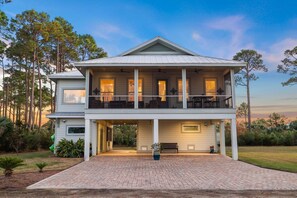 Enjoy outdoor dining or relaxation on the furnished balcony overlooking a tranquil lawn and trees.