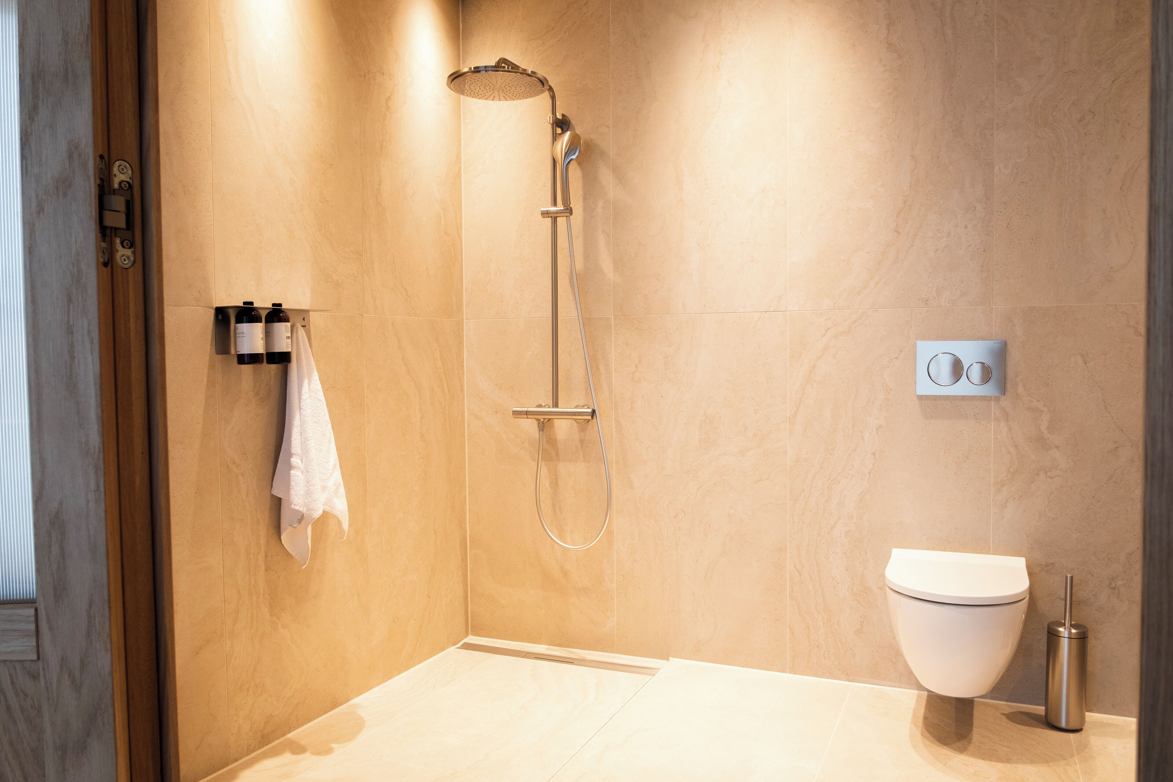 Ein modernes Badezimmer mit Dusche, Toilette und Handtuchhalter.