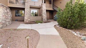 A two-story building with a stone facade, a balcony, and a well-maintained garden with a small tree. - *NEW* Mooseberry Villa • King Bed • eBikes • Nearby Fool Hollow Lake • Torreon (Show Low)