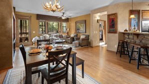 A spacious living room with a fireplace, a dining area with a wooden table and chairs, and a kitchen area with bar stools. - *NEW* Mooseberry Villa • King Bed • eBikes • Nearby Fool Hollow Lake • Torreon (Show Low)