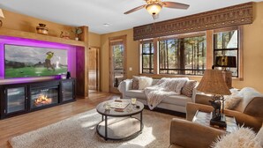 A living room with a fireplace, a television, and a ceiling fan. - *NEW* Mooseberry Villa • King Bed • eBikes • Nearby Fool Hollow Lake • Torreon (Show Low)