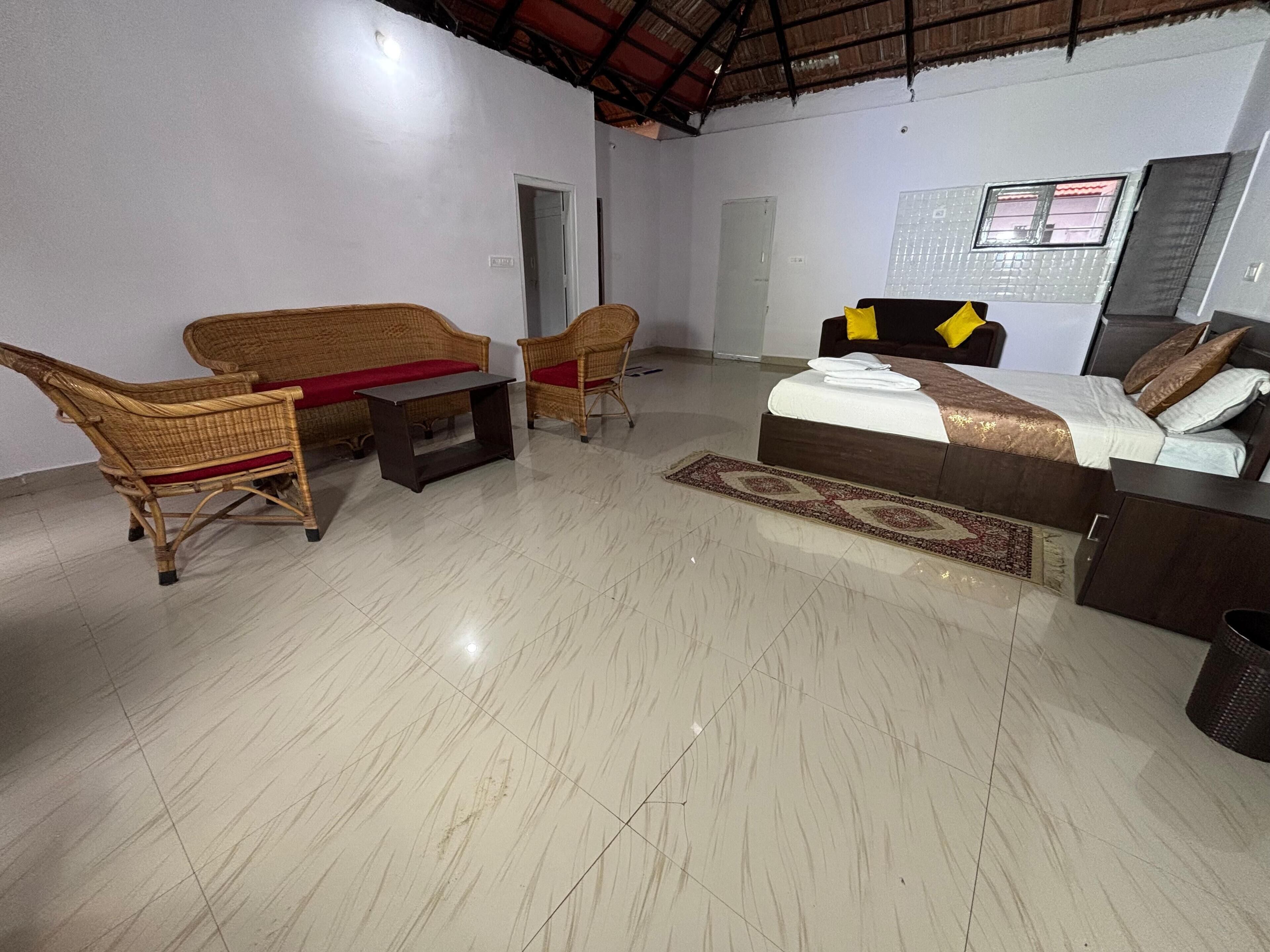 A room with a bed, a sofa, a chair, and a small table.