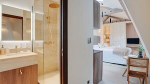 Une salle de bain moderne avec une douche à parois de verre, un meuble-lavabo avec un miroir et un meuble en bois.