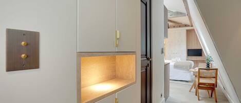 Een modern interieur met een houten vloer, een witte muur met lichtschakelaar en een houten stoel in een eetgedeelte.