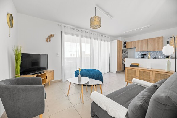 Relax in a spacious living area with a sofa, armchair, and flat-screen TV.