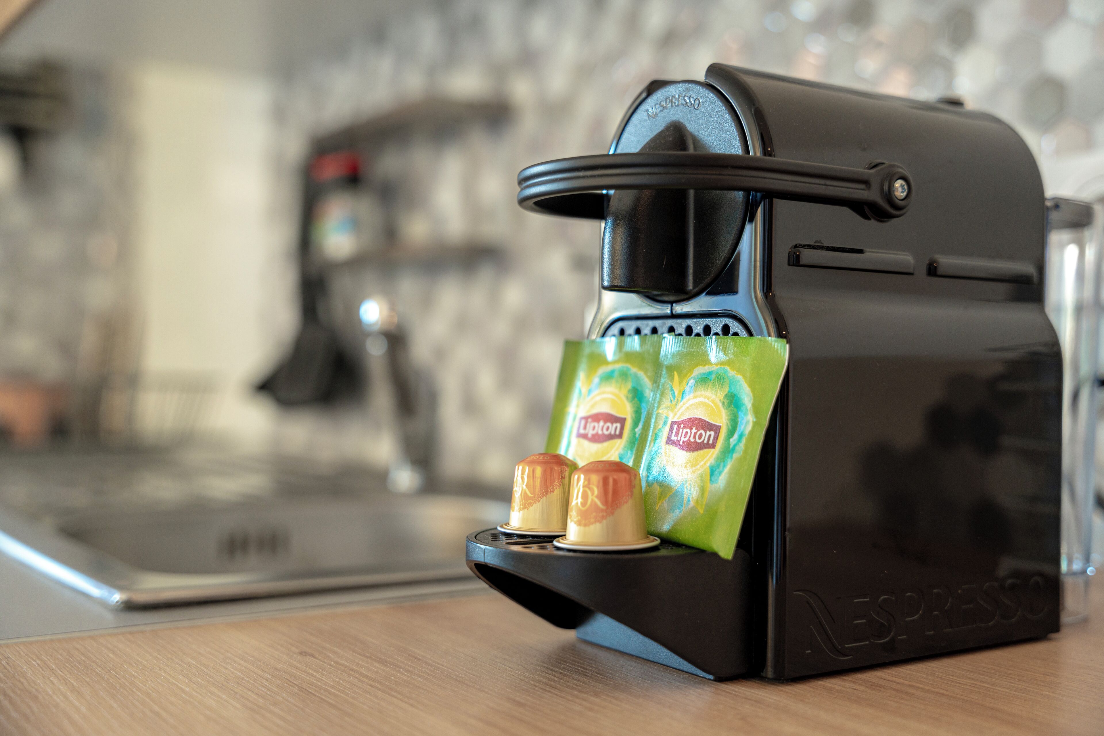 Una máquina de café Nespresso con dos bolsitas de té Lipton.