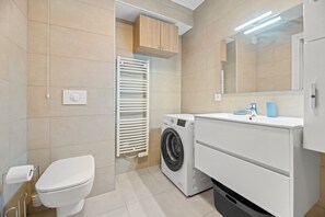 Features a washing machine, separate toilet, and ample storage.
