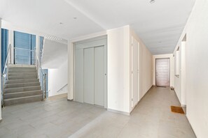Stairs lead to an upper level, with a door and a doormat at the entrance.