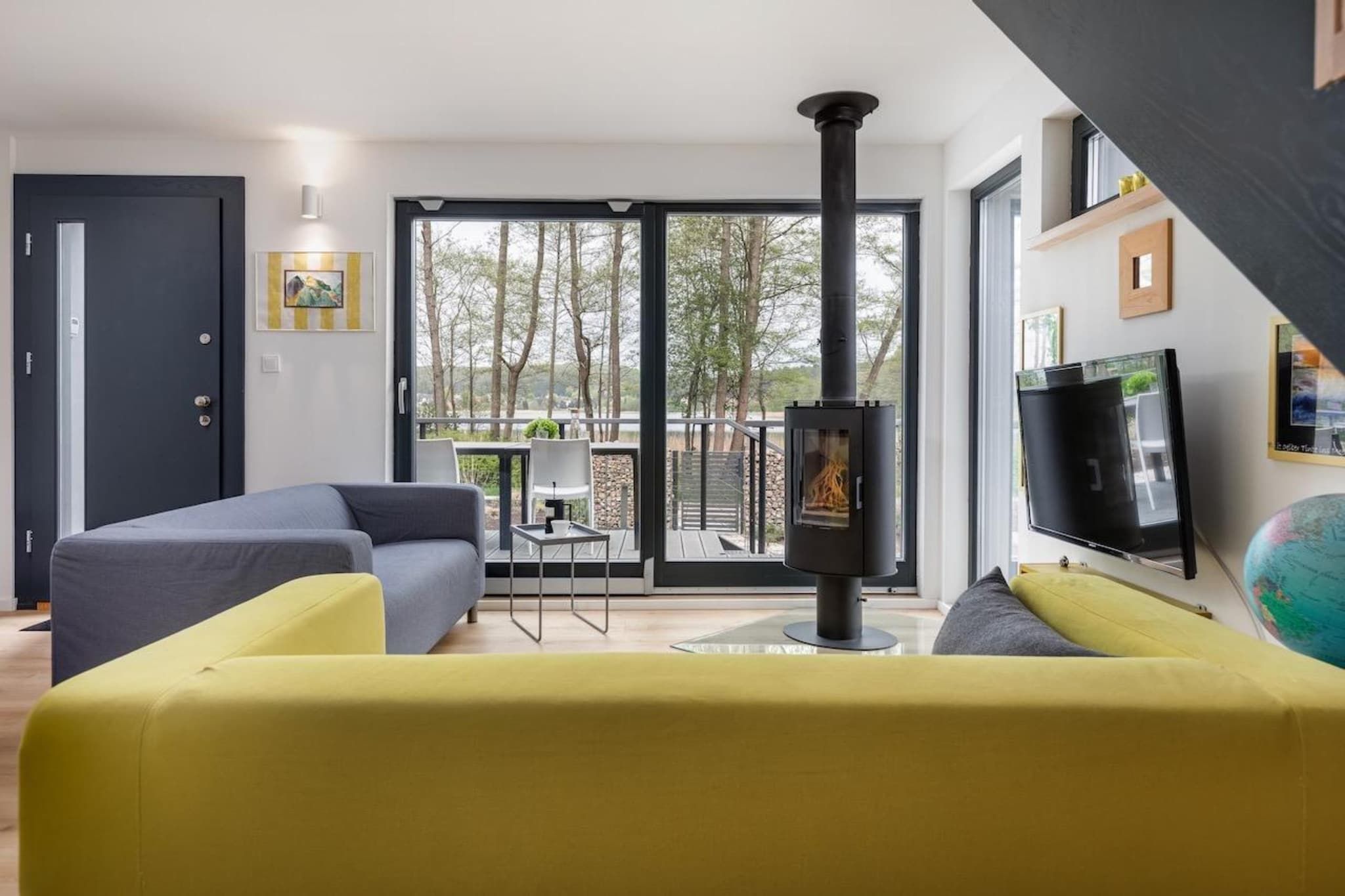 A modern living room with a sofa, a television, and a fireplace.