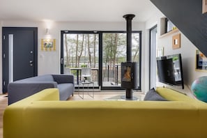 A modern living room with a sofa, a television, and a fireplace.