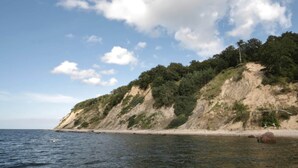 A coastal landscape with a sandy beach, a rocky cliff, and a clear sky. - Holiday Home by Lake Wisełka with Sauna (Wiselka)