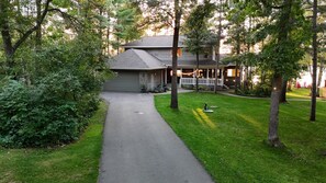 A two-story house with a covered porch and a driveway leading to the garage.