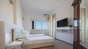 A modern bedroom with two beds, a desk, a TV, and a wardrobe. - Vaticano84 Gemelli (Rome)