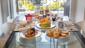 A breakfast table with various food items, a coffee maker, and a view of the outdoors. - Vaticano84 Gemelli (Rome)