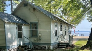 Une maison de plain-pied avec un porche, une petite terrasse et une vue sur l’eau.