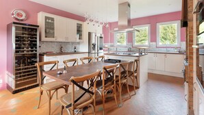 Una cucina moderna con isola centrale, mobili bianchi e un piccolo frigorifero per vini.