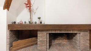 Una panchina di legno rustica con un camino in pietra sottostante.
