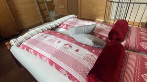 A bed with a patterned bedspread, a wooden ladder, and a mirror on the wall. - Cozy vacation home surrounded by nature, pets allowed. (San Giacomo Filippo)