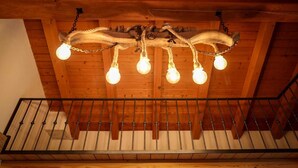 A wooden ceiling with a chandelier and a metal railing. - Cozy vacation home surrounded by nature, pets allowed. (San Giacomo Filippo)