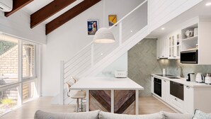 A modern kitchen with white cabinetry, a built-in microwave, and a stainless steel sink. - Pet Friendly - Captain Sandy on the Loop Blairgowrie (Blairgowrie)