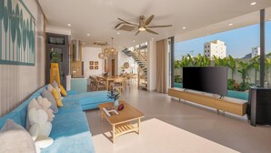 Ein modernes Wohnzimmer mit einem blauen Sofa, einem Holztisch und einem Fernseher auf einem Holzständer.