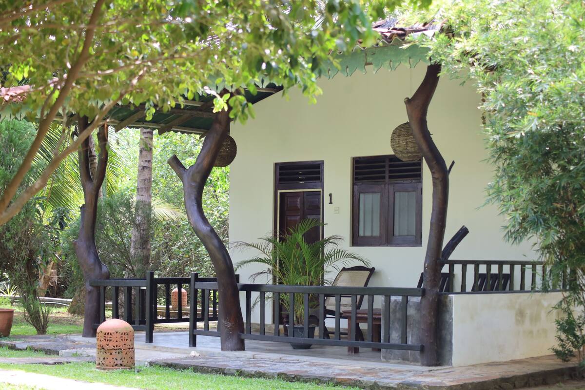 Un espacio de estar al aire libre cubierto con un banco, una planta en maceta y un pilón de piedra.