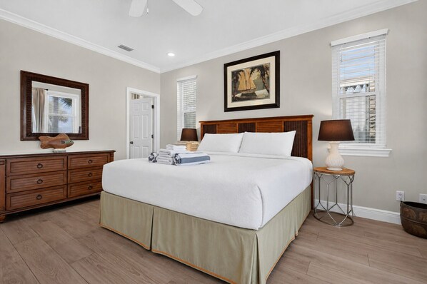 A bedroom with a bed, dresser, bedside tables, and a painting on the wall. - No Worries - Beach Front, Pet Friendly, Beach Gear Credit included! (St George Island)