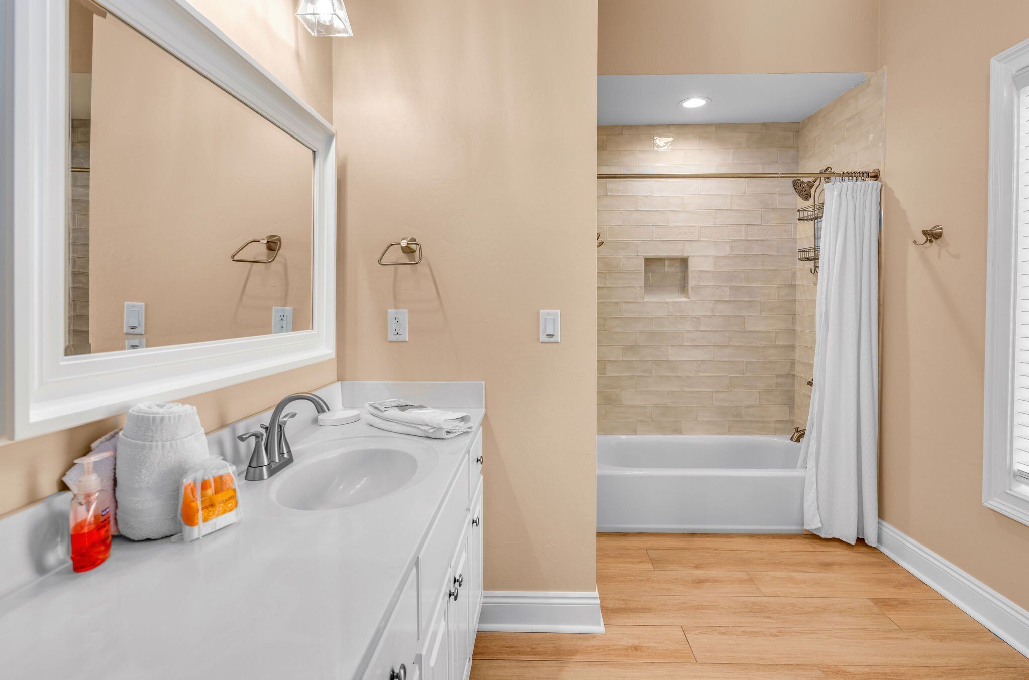 Une salle de bain avec un double vasque, un grand miroir, une baignoire et un espace douche.