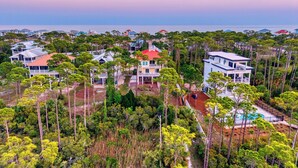 Un quartier résidentiel situé sur la côte, composé de plusieurs maisons entourées d’une végétation luxuriante et offrant une vue dégagée sur l’océan.
