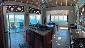 Eine Küche mit Meerblick, einem Deckenventilator und einem Essbereich mit Aussicht.